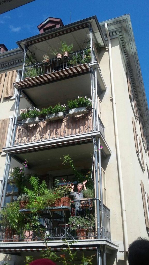 a lady in balcony greeting passerby