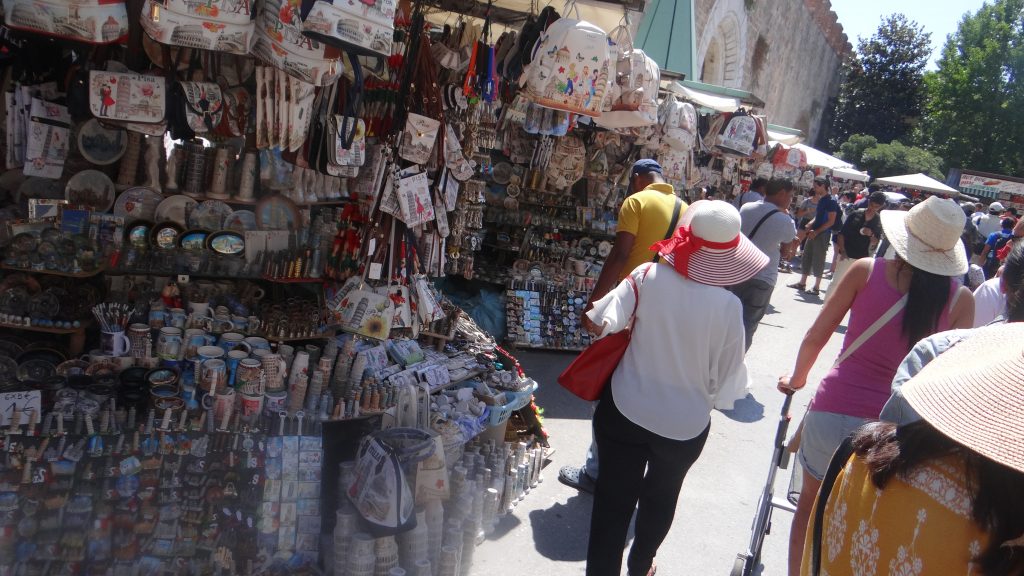 A leaning cylindrical tower of Romanesque architecture, Souvenir stalls, Pisa